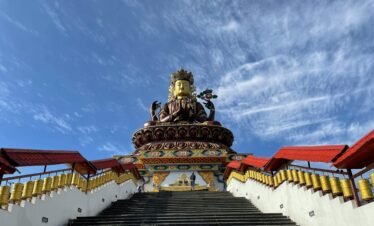 Majestic Maitreya Buddha statue under a clear blue sky in Pelling, Sikkim.
