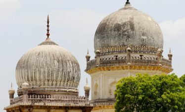 Stunning architectural shot of Qutb Shahi Tombs showcasing intricate domes and lush greenery in Hyderabad, India.